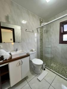 a bathroom with a toilet and a shower and a sink at Pousada Cinnamon in Canela