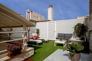 マラガにあるホテル デル ピントールの緑の芝生と家具が備わるパティオ