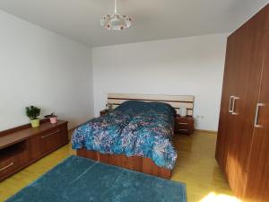 1 dormitorio con 1 cama con edredón azul en M K L Studio en Alba Iulia