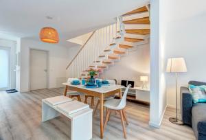 a living room with a table and a staircase at Bernsteinquartier BQ 9c Ostseenest in Kolpinsee