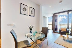 a dining room with a glass table and chairs at Superb Studio in Greenwich with balcony & roof top in London