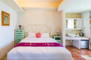 a bedroom with a bed with a red heart on it at Banani Resort By WB Inn in Gosāba