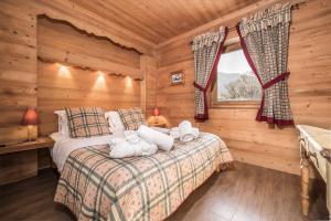 una camera con un letto in una baita di tronchi di Madame Vacances Chalet La Grande Sassière a Val dʼIsère