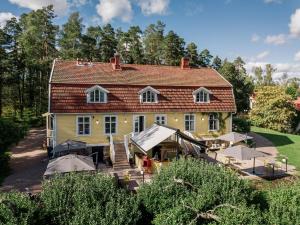 a large yellow house with a roof at Tammiston Cottages in Naantali