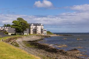 a large house on the shore of a body of water at Redcastle Hotel in Moville