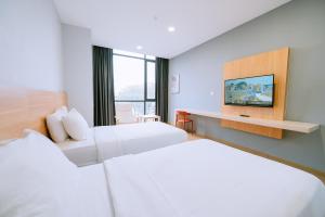 a hotel room with two beds and a tv at Signature by The Concept in Kuah