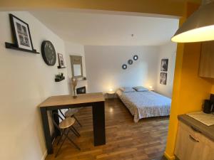 1 dormitorio con cama, escritorio y mesa en Superbe T2 entre Paris et Disney (RER A), en Nogent-sur-Marne