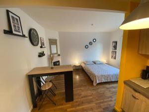 a bedroom with a bed and a desk and a table at Superbe T2 entre Paris et Disney (RER A) in Nogent-sur-Marne