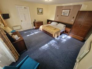 a bedroom with a bed, chair, and desk in it at Grange Lodge Hotel in Saint Peter Port