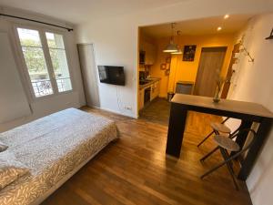1 dormitorio con cama, escritorio y cocina en Superbe T2 entre Paris et Disney (RER A), en Nogent-sur-Marne