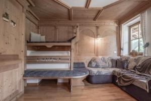 a living room with a couch and bunk beds at Apartment Dolomites Nest in San Martino in Badia