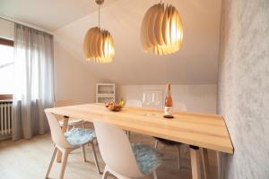 comedor con mesa de madera y 2 luces en Ferienwohnung Fischer, en Holzmaden