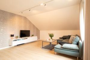 sala de estar con sofá y TV en Ferienwohnung Fischer, en Holzmaden