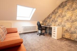an attic office with a desk and a chair at Ferienwohnung Fischer in Holzmaden