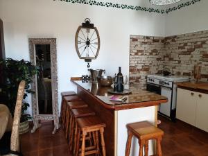 a kitchen with a counter with chairs and a clock on the wall at Casa Blas in Puerto del Rosario