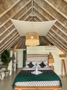 ein Schlafzimmer mit einem Bett und einer Decke in der Unterkunft Woywoy Escape Samu (Adults Only) in Ubud