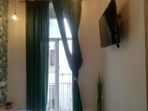 ventana con cortinas azules y TV en BnB Simy3, en Nápoles