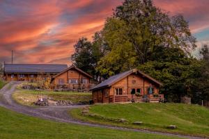 a cabin on a hill with a sunset in the background at Bothy Cabin -Log cabin in wales - with hot tub in Newtown