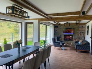 a dining room with a table and chairs and a fireplace at 4U LUXURY VILLA in Dospat