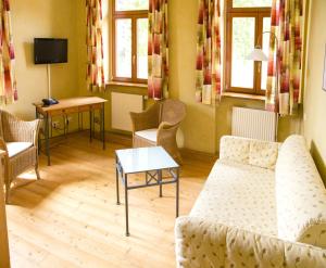 フロンハイムにあるLandhotel & Weingut Espenhofのリビングルーム(ソファ、椅子、テーブル付)