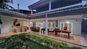 una casa con una mesa de ping pong en un patio en Piscina Aquecida, 5 suítes, Bilhar, Varanda Gourmet, 100mts mar, en Itanhaém