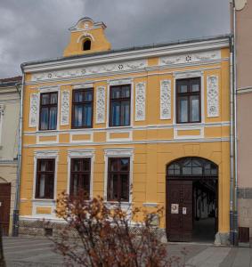 a yellow building with a clock tower on top of it at Zengő in Miercurea-Ciuc