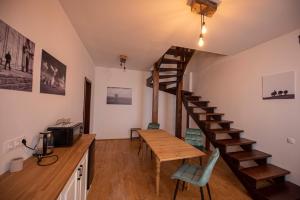 a room with a wooden table and a spiral staircase at Zengő in Miercurea-Ciuc