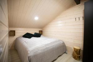 een slaapkamer met een bed in een houten kamer bij Korpi in Äkäslompolo