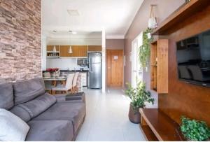 uma sala de estar com um sofá e uma cozinha em apartamento cobertura , proximo a praia grande , Ubatuba em Ubatuba