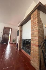 sala de estar con chimenea y pared de ladrillo en NOVIEMBRE La Iruela, en La Iruela