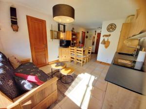 uma sala de estar com um sofá e uma cozinha em Appartement Samoëns, 3 pièces, 4 personnes - FR-1-624-73 em Samoëns