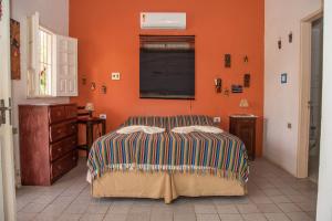 um quarto com uma cama e uma parede laranja em Serrambi Praia Suites em Porto de Galinhas