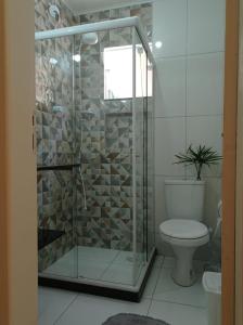 ein Bad mit einer Glasdusche und einem WC in der Unterkunft Aluguel temporada no Centro de Búzios in Búzios