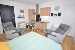 a living room with chairs and a table and a kitchen at Studio meublé 3 étoile 236 in Vittel