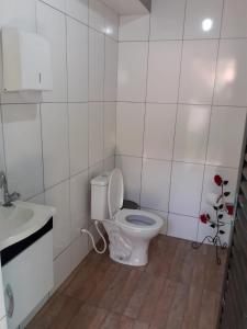 a white bathroom with a toilet and a sink at Casa das Violetas - Serra do Cipó in Serra do Cipo