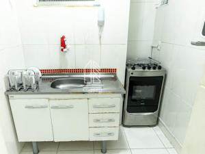 a white kitchen with a sink and a stove at Copacabana Barata Ribeiro 135 in Rio de Janeiro