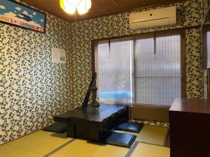 een woonkamer met een bank en een raam bij Hanakiya in Kyoto