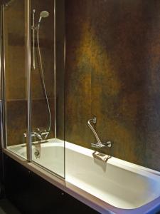 baño con ducha y puerta de cristal en The Abbey Lodge Hotel en Bradford