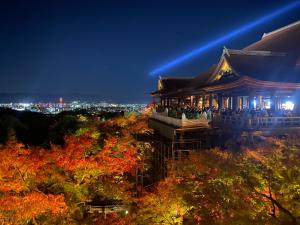 a chinese building at night with a city in the background at Hanakiya in Kyoto