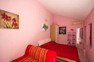 um quarto com uma cama vermelha e um sofá vermelho em Apartments Colours em Biograd na Moru