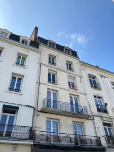 a large white building with windows and balconies at Plage port tout à pied in Dieppe
