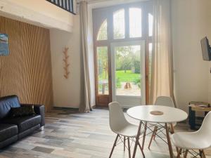 a living room with a couch and a table and a window at Le Clos de Kermadec in Kervignac