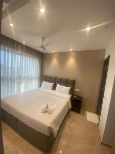 a bedroom with a large bed with white shoes on it at Maxxvalue Apartment Hiranandani Powai - RH5 in Mumbai