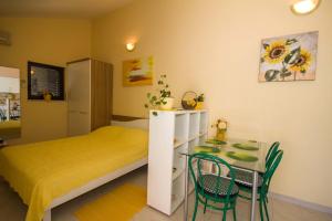 um quarto com uma cama, uma mesa e cadeiras em Apartments Colours em Biograd na Moru