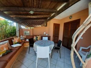 uma sala de estar com uma mesa e um sofá em CASA SIBILLA bi-locale con terrazza a 60 metri dal mare em Marinella