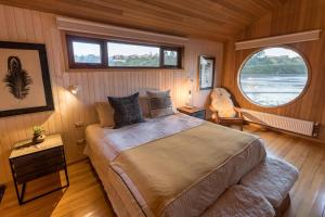 um quarto com uma cama e uma grande janela em Bledford Chiloé em Castro