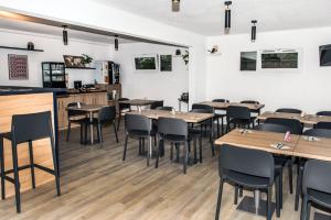 uma sala de jantar com mesas e cadeiras de madeira em Terres de France Brest em Brest