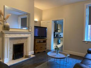 a living room with a fireplace and a tv at Alexander Apartments Jesmond in Newcastle upon Tyne