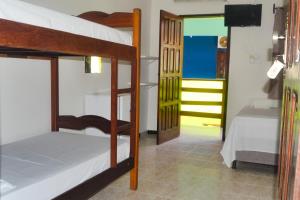 a room with two bunk beds and a doorway at Hotel Marujo in Morro de São Paulo