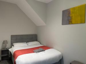 ein Schlafzimmer mit einem Bett mit einem Hemd drauf in der Unterkunft Alexander Apartments Jesmond in Newcastle upon Tyne